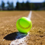 Softball in a softball field in California mountains on a white line